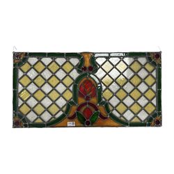 Early 20th century stained and leaded glass panel with lozenges and stylised floral decoration 75cm x 39cm
