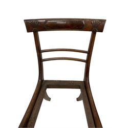 Set of eight Regency rosewood and beech dining chairs, the bar back with carved decoration and applied rosewood panels over two slender middle rails, on sabre supports, the carver with scrolled arms