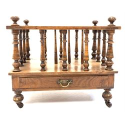 Victorian walnut two division Canterbury, spindle uprights, single frieze drawer, raised on turned supports with brass and ceramic castors W53cm