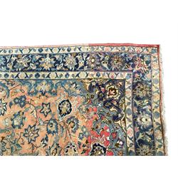 Antique Iranian Nanaj peach ground rug, the field decorated with a central indigo floral pole medallion, surrounded by scrolling interlacing palmettes and foliate decoration with matching spandrels, the triple band border with repeating foliate motifs