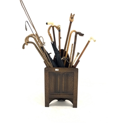 Oak corner stick stand containing various sticks, riding crop and whip, Greek stick with horses head etc