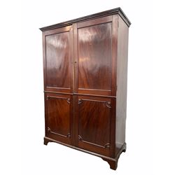 Georgian mahogany knock down wardrobe, projecting cornice over two panelled doors enclosing interior fitted for hanging, raised on bracket supports W138cm, H213cm, D60cm 