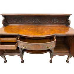 Early to mid-20th century walnut sideboard, the raised panelled back carved with geometric designs and heavily carved fruit and flower oval panels, the convex front fitted with single drawer and flanked by ornate foliate carved cupboard doors, raised on cabriole supports with moulded acanthus leaves terminating in ball and claw feet