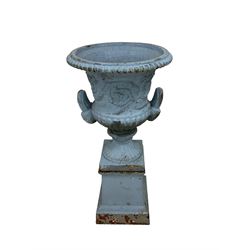 Late 19th century cast iron centre-piece painted urn planter, the moulded top over relief frieze decorated with scrolling garlands and flowerheads,  the twin handles with masks flanked by gadroon patterns, raised on plinth base