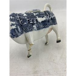 Two Victorian Staffordshire cow creamers with blue and white printed Willow pattern bodies on green painted oblong bases, together with another pair of Willow pattern cow creamers (4)