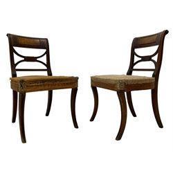 Pair of Regency mahogany chairs, the cresting rail inlaid with trailing geometric ebony banding and moulded figured panel, curved x-frame back with moulded uprights, on sabre front supports with single ebony band