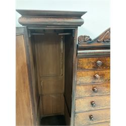 Victorian double wardrobe, the scrolled cornice over six graduated drawers, flanked by two doors, opening to reveal interior fitted for hanging, raised on a plinth base 