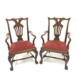  Pair of 19th century Chippendale style library elbow chairs, with ribbon carved cresting rail and pierced splats, swept open arms over drop in red upholstered seat panels, raised on cabriole supports with ball and claw feet united by turned stretchers, W65cm  