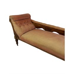 Victorian chaise longue, the walnut frame with buttoned back red fabric raised on turned supports, terminating in ceramic castors 