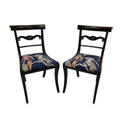 Pair of early Regency lacquered mahogany chairs, centre rail with gilt metal cornucopia mount, seat upholstered in aviary marine fabric, raised on sabre supports