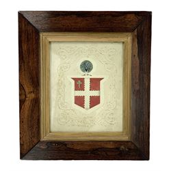 19th century embossed pressed paper crest heightened with watercolour with a quartered shield surmounted by a peacock 25cm x 20cm in rosewood frame