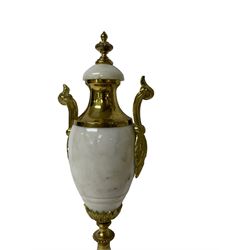 French - Early 20th century white marble and gilt-metal striking portico mantel clock and garniture, circa 1910, with four free-standing columns above a shaped plinth raised on four feet, gilt metal drum case surmounted by two small nesting birds, convex enamel dial with floral garlands and Arabic numerals, gilt Louis XV hands and minute markers, 8-day outside countwheel striking movement striking the hours and half hours on a bell, with a sunburst pendulum and matching pair of garniture urns with conforming decoration.