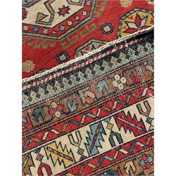 Persian red ground rug, overall geometric design, the field with three main medallions and decorated with stylised motifs, multi-band border decorated with stylised plant motifs