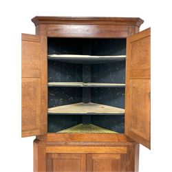 George III oak standing corner cupboard, stepped cavetto cornice over frieze with mahogany banding, top section fitted with two panelled cupboards enclosing a blue painted interior with four shelves and brass hooks, lower double cupboard enclosing two shelves, each with ivory escutcheons, raised on turned feet

This item has been registered for sale under Section 10 of the APHA Ivory Act