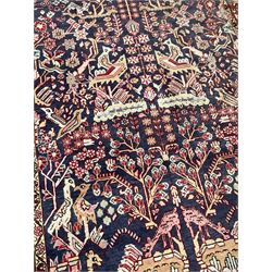 Persian indigo and crimson ground rug, the busy field filled with various bird and camel motifs surrounded by stylised plant designs, the guarded border with repeating bird and floral sequences 