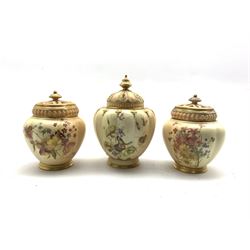 Pair of Royal Worcester pot pourris and covers decorated with floral sprays on a blush ivory ground H14cm and a single Worcester pot pourris 'The Stuart' made for Stonier & Co. Liverpool H18cm