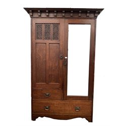 Edwardian oak double wardrobe, dentil cornice over door with floral carved panels, flanked by mirrored door, enclosing interior fitted for hanging, three drawers under W133cm, H204cm, D56cm