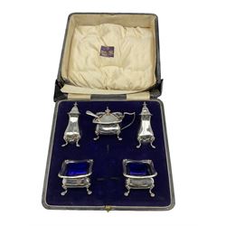 Silver condiment set comprising pair of salts with blue glass liners, pair of pepperettes and mustard pot with blue glass liner Birmingham 1945 Maker Henry Matthews, cased