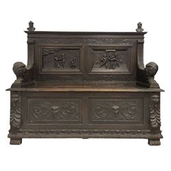 Late 19th century carved oak monks bench, the back panel with carved figures over hinged seat and base with carved masks 