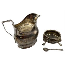 Early 19th century silver cream jug with angular handle H10cm, a George III silver circular salt, both marks rubbed and a silver salt spoon (3) 