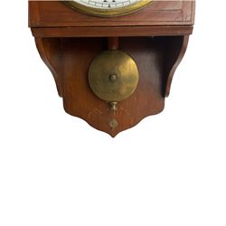 English - 20th century 8-day Fusee wall clock in a mahogany case, ogee shaped pediment, movement bracket and conforming apron, 8” painted metal dial with Roman numerals, minute track and steel spade hands, with a cast brass bezel and flat glass. Pendulum with a drilled central locking keep.
