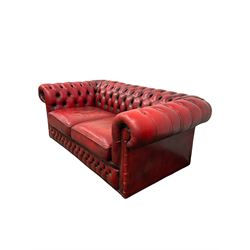 Chesterfield two seater sofa, the buttoned back and arms and two squab cushions upholstered in red fabric 
