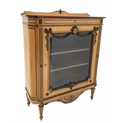 Late 19th century Regency design satinwood glazed cabinet, the raised and floral carved back over rosewood cross banded top, frieze drawer with further rosewood banding, the glazed door with applied swags enclosing two adjustable shelves, shaped apron under with incised carving, raised on turned tapered and fluted supports 