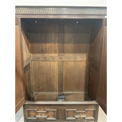 Late 18th century oak hanging cupboard, the projecting cornice over fluted frieze surmounting two panelled doors with geometric and rounded design enclosing hanging rail, leading into two drawers in geometric design, raised on stile supports W135cm, H195cm, D58cm