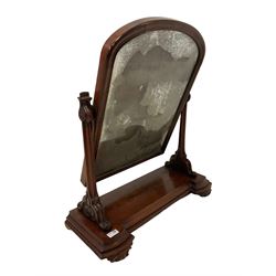 Early Victorian figured mahogany dressing table mirror, arched moulded frame supported by moulded and scroll carved horns, moulded platform on scrolled foliage carved feet