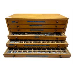A six drawer printers chest containing a quantity of metal stamps/ matrices and other accessories, H25cm, W51cm, D25.5cm