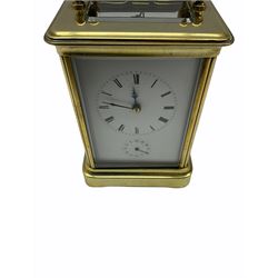 A late 19th century French Corniche cased carriage clock with alarm sounding on a bell, eight-day timepiece movement with a platform cylinder escapement, white enamel dial with roman numerals, minute track and steel hands, subsidiary alarm dial with counter-clockwise Arabic numerals. half-hour markers and setting hand, bevelled glass panels to the case and a rectangular glass panel to the top of the case. 