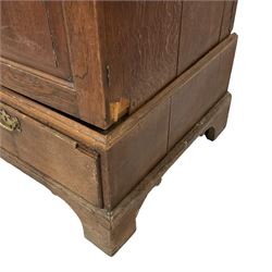 George III oak linen press, moulded rectangular top over two panelled doors enclosing two slides, the base fitted with two drawers, on bracket feet