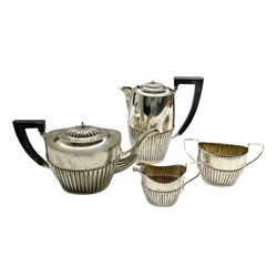 Silver four piece tea set of oval design with half body reeded decoration, the tea pot and hot water jug with ebonised handles Birmingham 1921/3 Maker A & J Zimmerman 33.4oz gross
