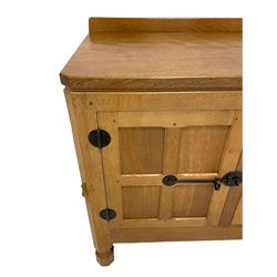 Mouseman - oak dresser, rectangular adzed top with raised back over three central drawers and two flanking cupboards, enclosed by panelled doors with wrought metal fixtures, the canted upright carved with mouse signature, on octagonal feet, by the workshop of Robert Thompson, Kilburn