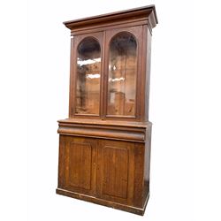 Victorian scumbled pine bookcase on cupboard, projecting cornice over two glazed doors enclosing two shelves, cushion fronted frieze drawer and double to base W105cm