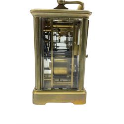 Early 20th century twin train Corniche striking carriage clock with repeat button striking the hours on a coiled gong, eight-day movement with a jewelled lever platform escapement and balance timing screws, white enamel dial with Roman numerals, minute markers and steel moon hands, bevelled glass panels to the case and an oval glass panel to the top of the case, with original base plate. 
With Key.
