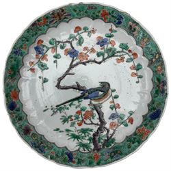 Chinese famille verte 'antiquities' plate, Kangxi period, centrally decorated with precious objects, within a stylized border, pictorial mark within double circles beneath, D22cm, together with a Chinese famille verte circular dish, enamelled with a bird perched on a flowering branch within a scalloped border of butterflied and foliage, D21cm. Provenance: From the Estate of the late Dowager Lady St Oswald