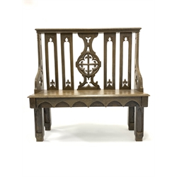19th century oak hall bench of Gothic design, with arched splats carved with fleur de lis, chamfered panel seat, raised on carved block supports 