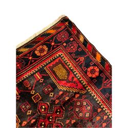 Persian Hamadan rug, stepped central lozenge decorated with geometric motifs, repeating border decorated with stylised flower heads, chequered lozenge outer-band