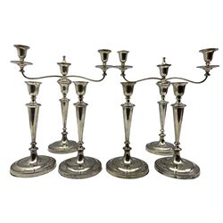 Set of four Edwardian silver candlesticks and pair of matching three light candelabra with tapering stems and reeded circular bases, one of the candalabra engraved with presentation inscription to 'Thomas Alexander Wallace, Town Clerk, Solicitor and Banker 1909' and engraved with a monogram, height of candlesticks 29cm, height of candelabra 42cm Sheffield 1908/9 Maker Hawksworth, Eyre & Co Ltd
