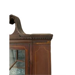 Edwardian mahogany corner cabinet, dentil broken swan neck pediment over astragal glazed door, the lower cupboard enclosed by panelled door with shell inlay, on shaped and bracketed plinth base 