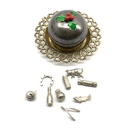  Silver and silver gilt novelty Christmas pudding by Stuart Devlin, the cover with holly sprig lift, containing nine silver charms on a pierced lace work base D8cm London 1977  