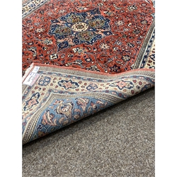 Persian Saroug ground rug, floral medallion on busy red field, floral decoration to border, 220cm x 135cm