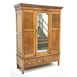 Early 20th century panelled oak wardrobe, projecting cornice over single bevel edged mirror glazed door, each panel with quarter book matching, two drawers to base, W149cm, H198cm, D57cm