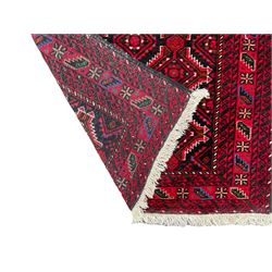 Persian red and indigo ground rug, overall geometric design, decorated with repeating stylised lozenge motifs, multiple band border each with repeating pattern, the central band with alternating stylised flower head and leaf motifs