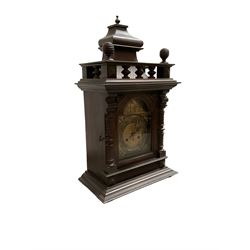 German - Edwardian oak cased 8-day mantle clock, with a raised pediment and gallery, break arch door with attached pilasters, resting on a stepped plinth, brass dial with spandrels, gothic steel hands, silvered chapter ring with Arabic numerals, rack striking movement striking the hours and half hours on a coiled gong. With   key and pendulum.