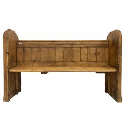 19th century waxed pine pew or bench, plank back with moulded cresting rails, raised on shaped and chamfered end supports