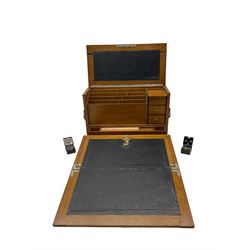Victorian oak stationary box with strapwork hinged cover with applied monogram, folding black leather writing surface and fitted interior interior of stationary compartments, H28cm x W42.5cm 