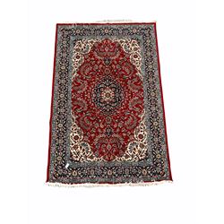 Persian Mashad red ground rug, navy medallion on field decorated with interlaced foliate and ivory spandrels, enclosed by border  197cm x 305cm
350 per inch