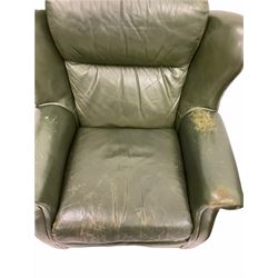 Pair of vintage green leather wing back armchairs, with loose cushions, raised on castors, W94cm